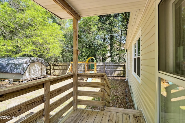 deck with a fenced backyard and an outdoor structure