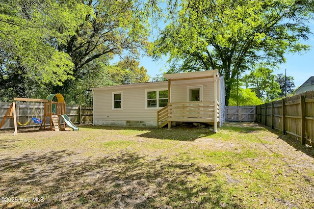 rear view of property featuring a yard, a fenced backyard, a playground, and crawl space