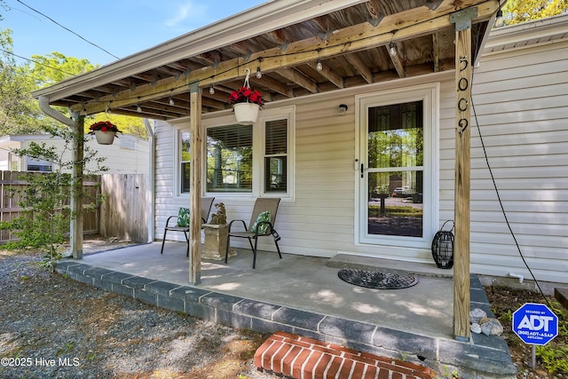 entrance to property with a porch and fence
