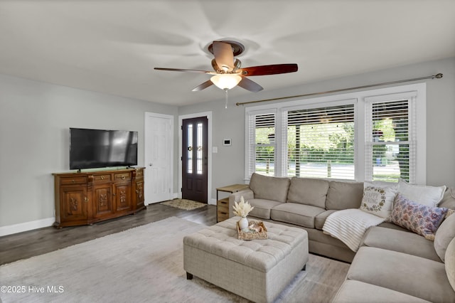 living room with ceiling fan, wood finished floors, and baseboards