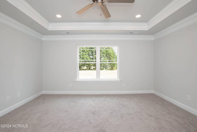 unfurnished room featuring carpet floors, a raised ceiling, ceiling fan, and crown molding