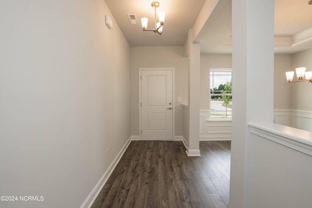 doorway with dark hardwood / wood-style flooring and an inviting chandelier