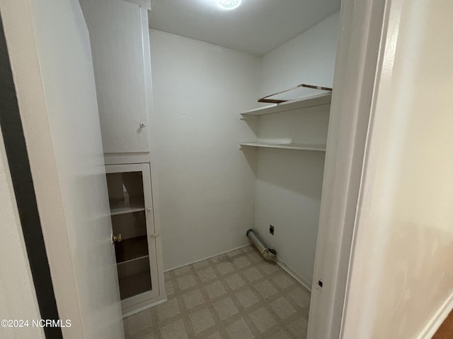 laundry area featuring electric dryer hookup and light tile floors