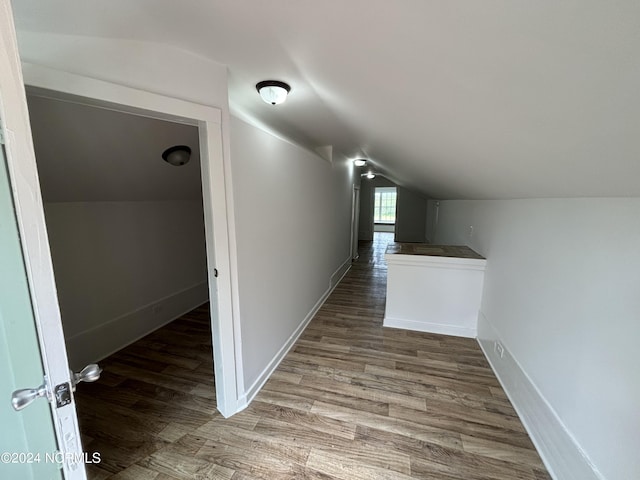 hallway with lofted ceiling and dark hardwood / wood-style floors