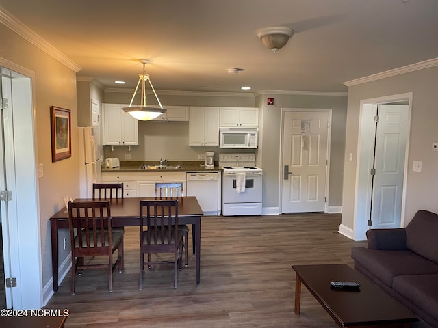 interior space featuring white appliances, decorative light fixtures, white cabinetry, crown molding, and dark hardwood / wood-style floors