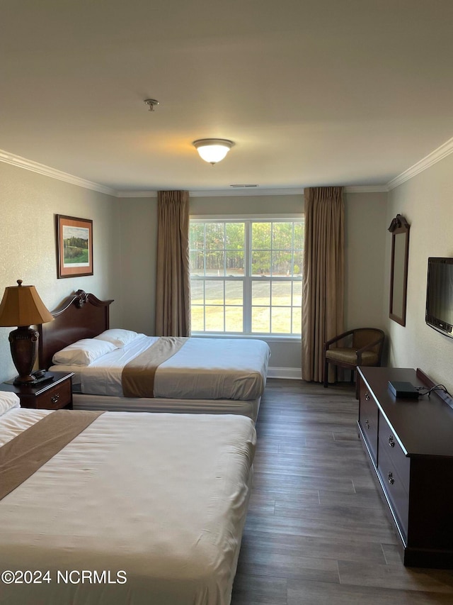 bedroom with ornamental molding and dark hardwood / wood-style flooring