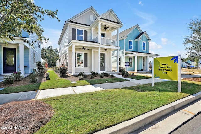 view of front of home with ceiling fan, a balcony, and a front yard