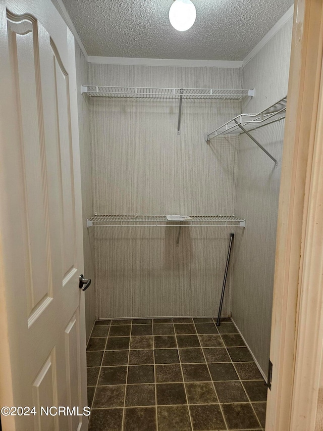 spacious closet with dark tile flooring