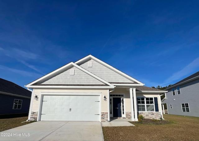 craftsman house with a garage and a front lawn