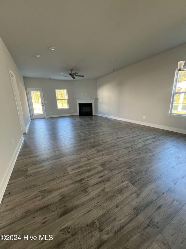 unfurnished living room featuring dark hardwood / wood-style floors and ceiling fan