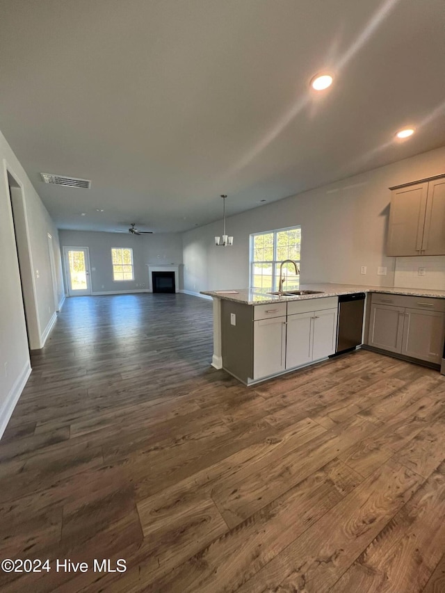 kitchen featuring dark hardwood / wood-style flooring, stainless steel dishwasher, ceiling fan with notable chandelier, and sink