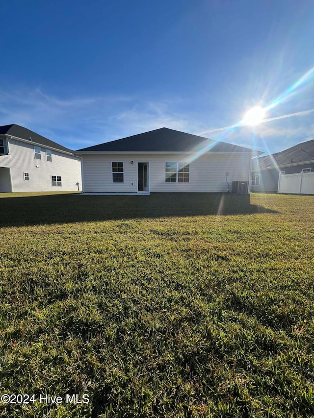 rear view of property featuring a lawn