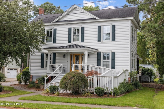 view of front of home with a porch, a garage, and a front lawn