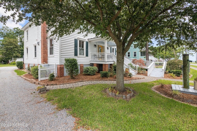 view of front of house with a front yard and a porch