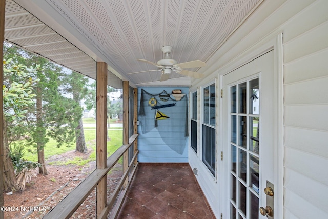 unfurnished sunroom with ceiling fan