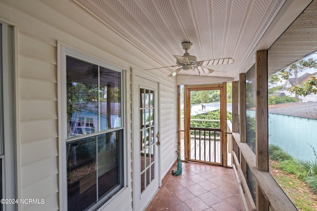 unfurnished sunroom featuring ceiling fan