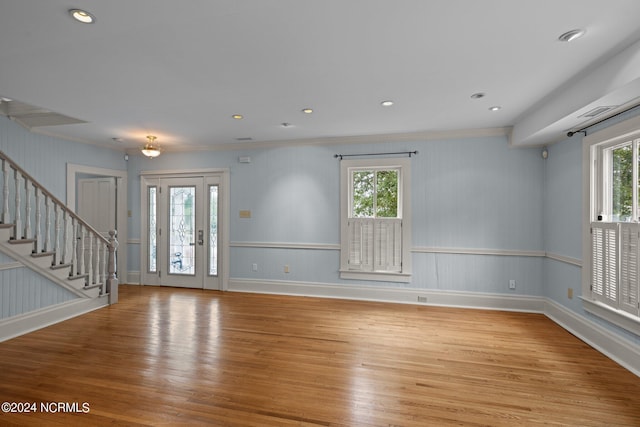 entrance foyer with crown molding and light hardwood / wood-style floors