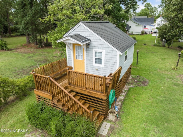 rear view of property with a wooden deck and a yard