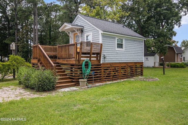 rear view of property with a yard and a wooden deck