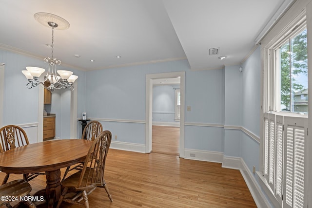 dining area featuring a notable chandelier, light hardwood / wood-style floors, and crown molding