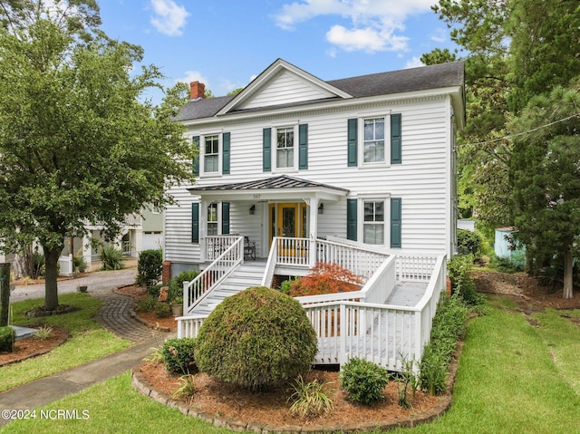 view of front facade with covered porch and a front lawn