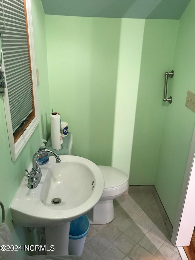 bathroom with sink, toilet, and tile patterned floors