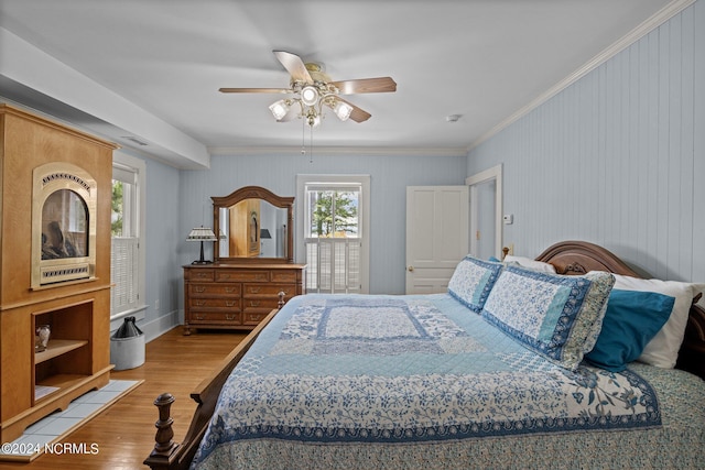 bedroom featuring ceiling fan, ornamental molding, and light hardwood / wood-style floors