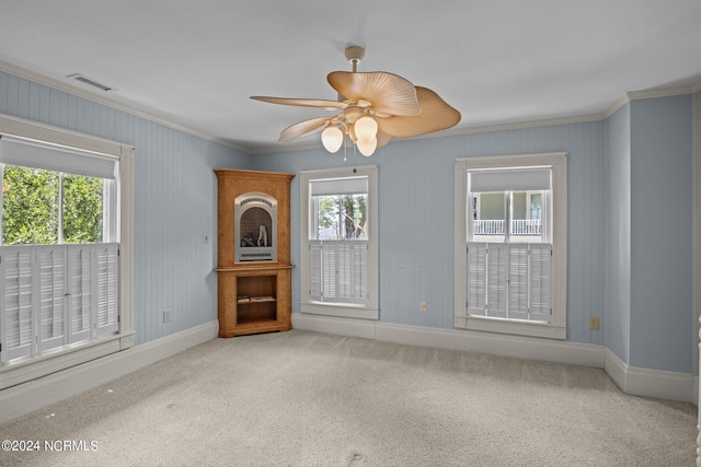 unfurnished living room featuring carpet, ceiling fan, and ornamental molding