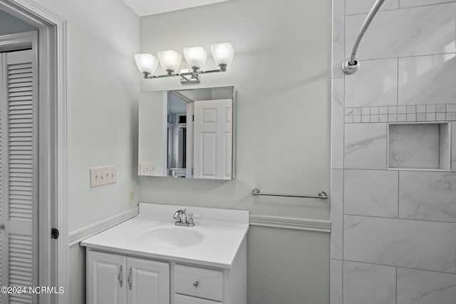 bathroom featuring a tile shower and vanity