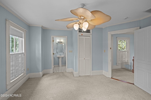 unfurnished bedroom with ceiling fan, ensuite bath, carpet floors, and multiple windows