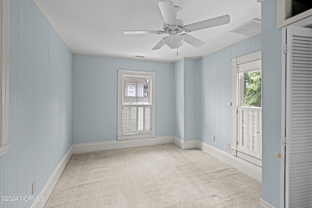 unfurnished room with ceiling fan, carpet floors, and crown molding