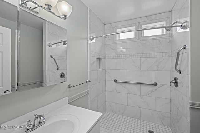 bathroom featuring a tile shower and vanity