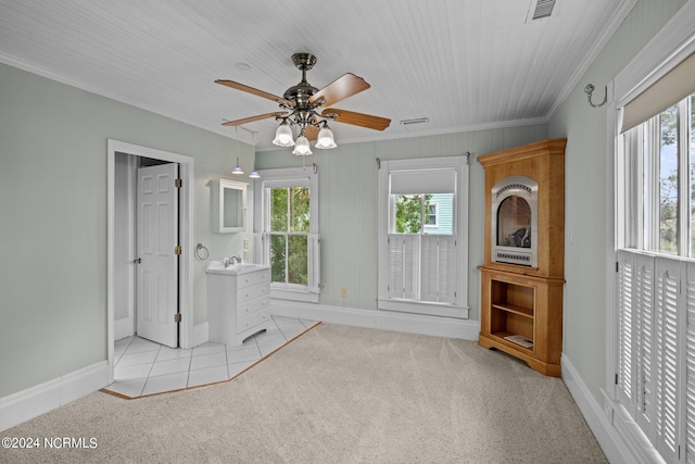 unfurnished bedroom featuring ceiling fan, light carpet, and crown molding