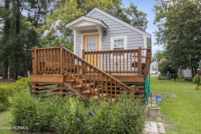 rear view of house with a deck and a lawn