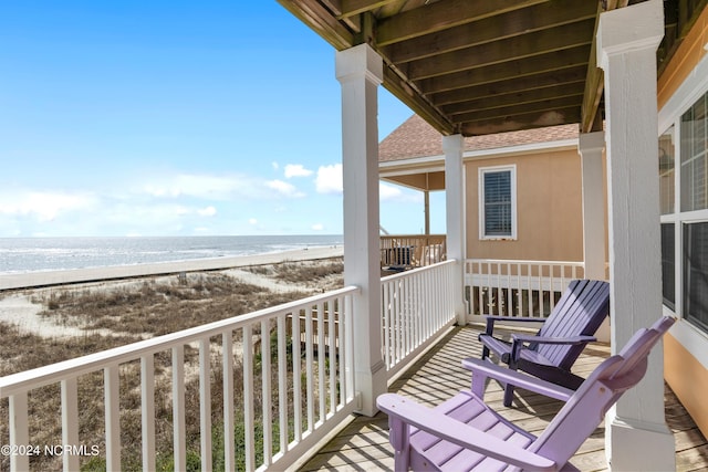 balcony with a water view and a beach view