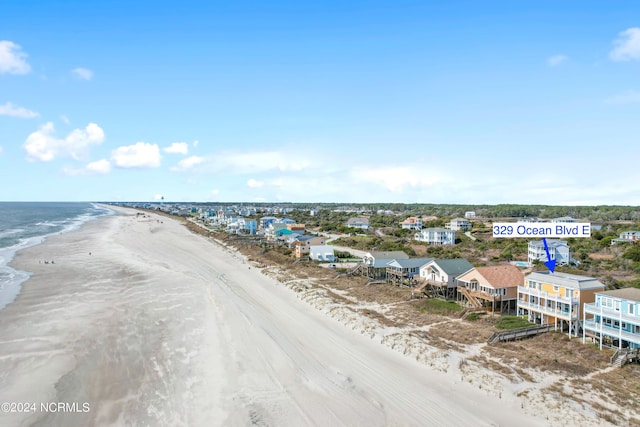 birds eye view of property with a water view and a beach view