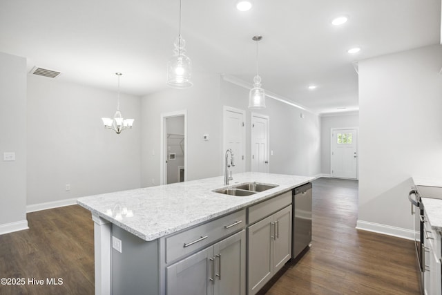 kitchen with gray cabinets, decorative light fixtures, a kitchen island with sink, and sink