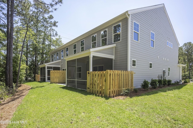 rear view of property with a yard and a sunroom