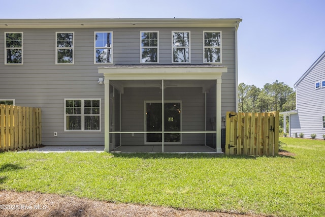 rear view of house with a lawn and a sunroom