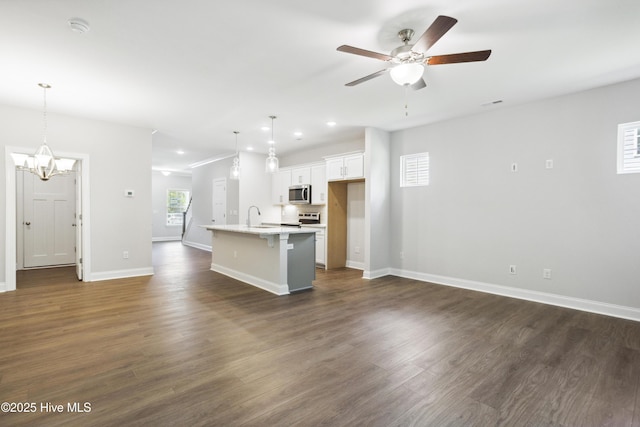 kitchen featuring pendant lighting, white cabinetry, a kitchen island with sink, and appliances with stainless steel finishes