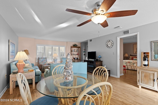 dining space with light hardwood / wood-style flooring and ceiling fan