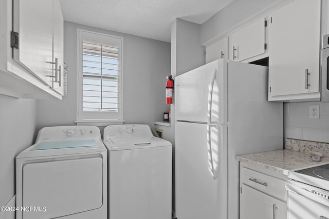 clothes washing area featuring washer and clothes dryer and a textured ceiling