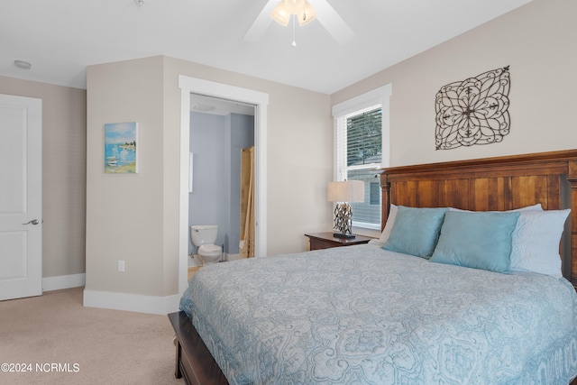 bedroom with light carpet, ensuite bathroom, and ceiling fan