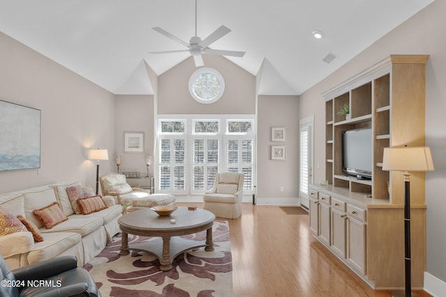 living room featuring high vaulted ceiling, ceiling fan, and light wood-type flooring