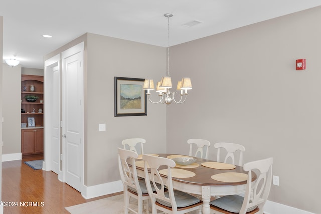 dining room featuring an inviting chandelier and light hardwood / wood-style flooring