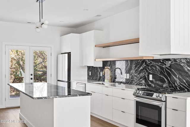 kitchen featuring light hardwood / wood-style floors, gas range, white cabinetry, white fridge, and a kitchen island