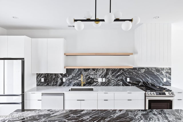 kitchen with dishwashing machine, white refrigerator, white cabinets, and sink