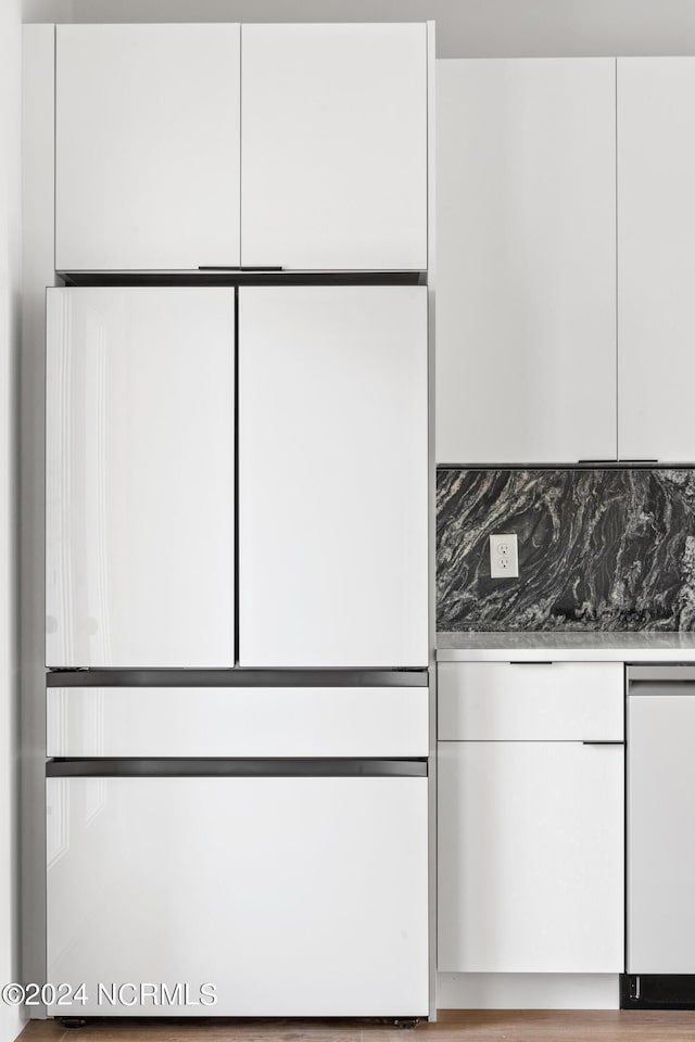 interior space with dishwashing machine, white cabinetry, and tasteful backsplash