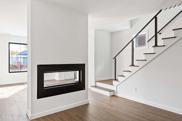 interior space featuring a multi sided fireplace and hardwood / wood-style floors