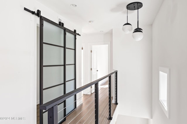 hallway featuring a barn door and dark hardwood / wood-style flooring